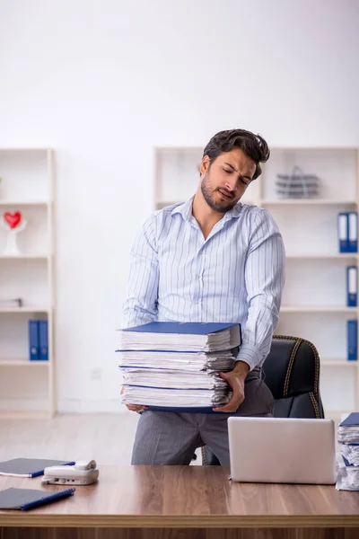 Joven empleado masculino descontento con el trabajo excesivo en la oficina — Foto de Stock