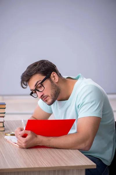 Jeune étudiant se préparant aux examens en classe — Photo