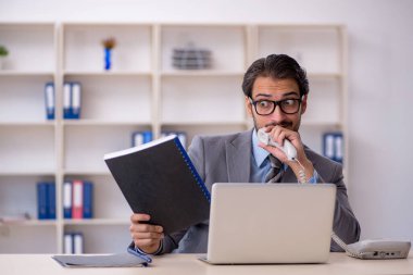 Ofiste çalışan genç bir erkek.