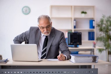 Ofiste çalışan yaşlı bir erkek.