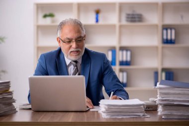 Ofiste çalışan yaşlı bir erkek.