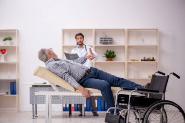 Yaşlı adam genç erkek doktor radyolojisti ziyaret ediyor.