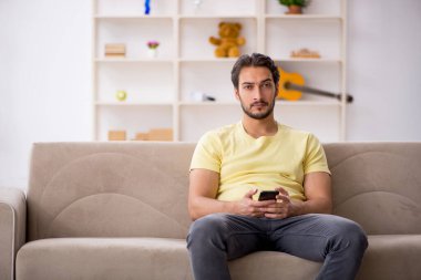 Genç adam salgın sırasında evde oturuyor.