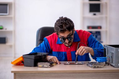 Bilgisayar tamir eden genç bir erkek tamirci.