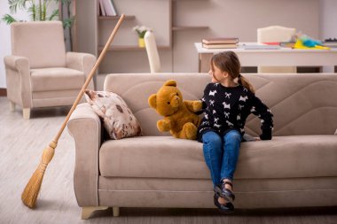 Küçük kız evde ev işi yapıyor.