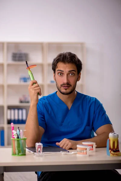 Ung manlig tandläkare som arbetar på kliniken — Stockfoto