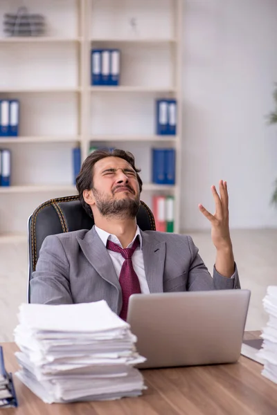 Junge männliche Mitarbeiter und zu viel Arbeit im Büro — Stockfoto