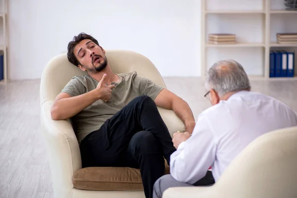 Jongeman op bezoek bij oude psycholoog — Stockfoto