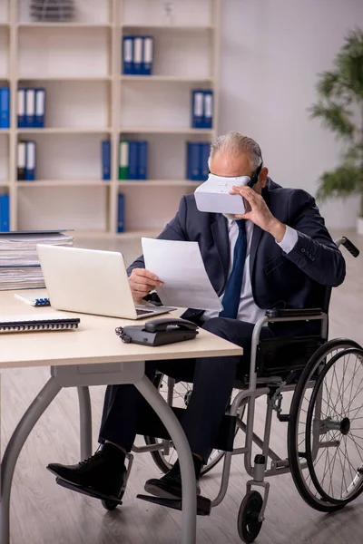 Vecchio gamba ferito maschio dipendente indossare occhiali virtuali a workpla — Foto Stock