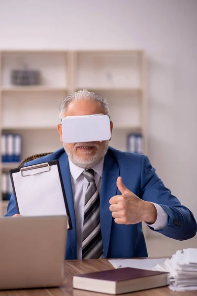 Åldrad man anställd bär virtuella glasögon på kontoret — Stockfoto