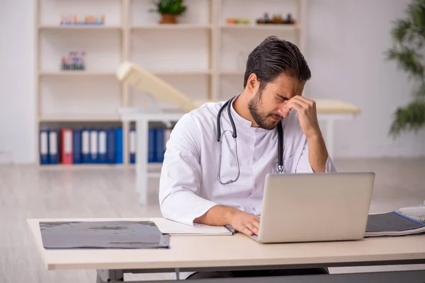 Jovem médico do sexo masculino trabalhando na clínica — Fotografia de Stock