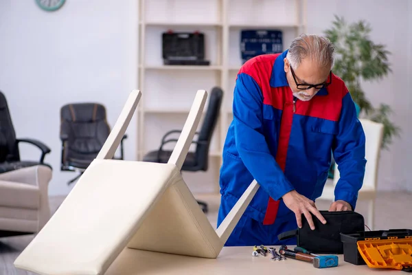 Yaşlı erkek marangoz sandalyeyi tamir ediyor. — Stok fotoğraf