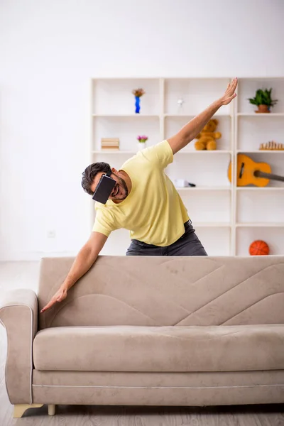 Fiatal férfi visel virtuális szemüveg otthon — Stock Fotó