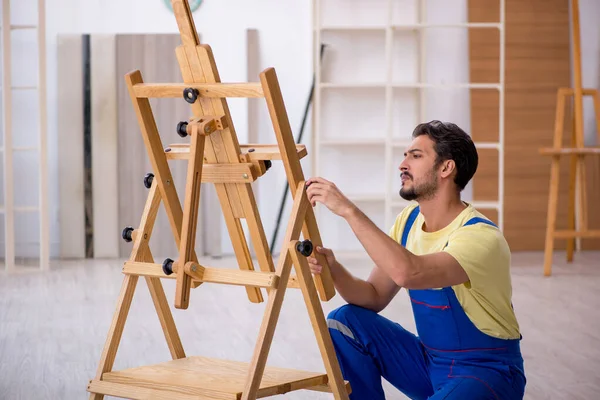 Joven reparador masculino reparando caballete en casa — Foto de Stock