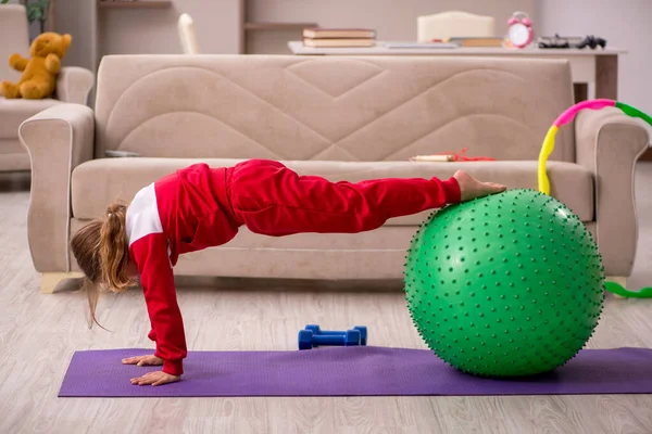 Niña haciendo ejercicios deportivos en casa —  Fotos de Stock