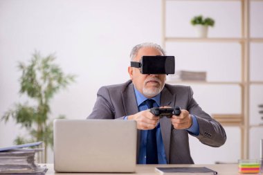 Eski erkek çalışanın iş yerinde sanal gözlüklerin keyfini çıkarması