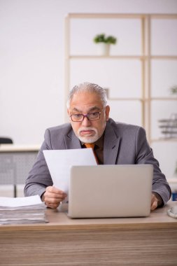 İş yerinde çalışan yaşlı bir erkek işçi.