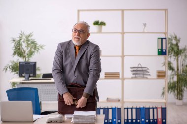 İş yerinde çalışan yaşlı bir erkek işçi.