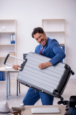 Genç bir erkek işçi iş yerinde geziye hazırlanıyor.