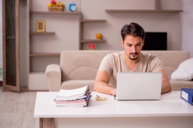 Evden çalışan genç bir erkek.