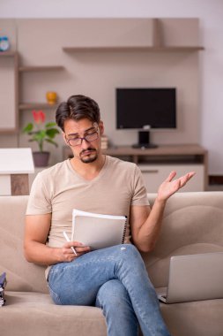 Evden çalışan genç bir erkek.