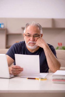 Salgın sırasında evde çalışan yaşlı bir erkek işçi.