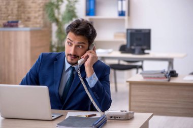 Ofiste çalışan genç bir erkek.