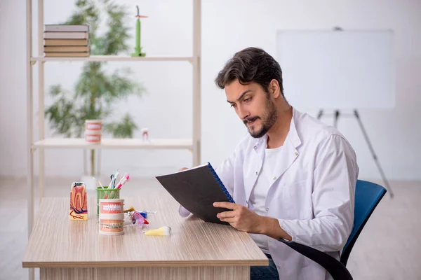 Jonge mannelijke tandarts werkzaam in de kliniek — Stockfoto