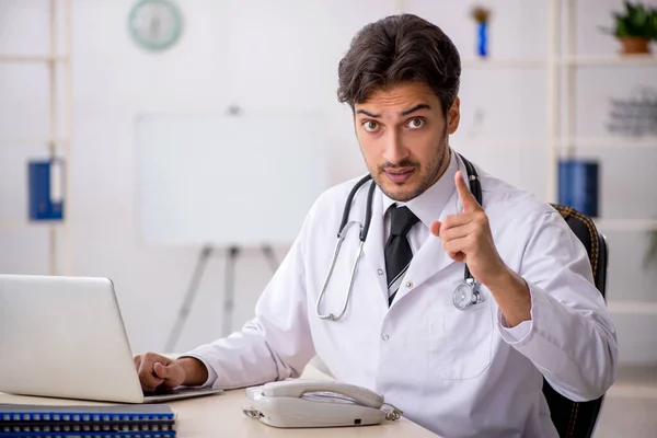 Joven médico masculino que trabaja en la clínica — Foto de Stock