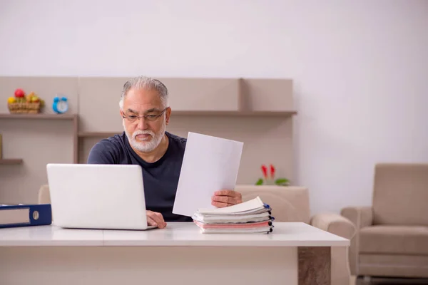 Gammal manlig anställd som arbetar hemifrån under en pandemi — Stockfoto