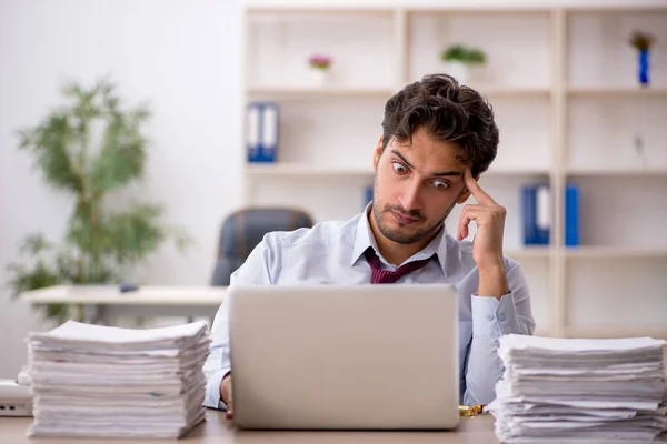 Jeune employé masculin et trop de travail au bureau — Photo