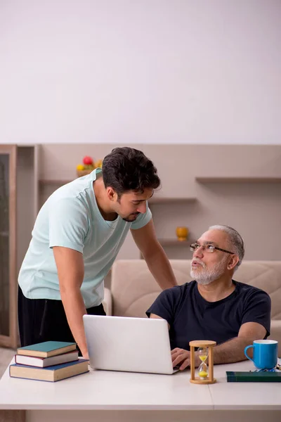 Дедушка и внук дома с компьютером — стоковое фото