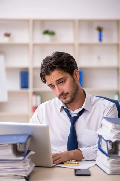 Jeune employé masculin et trop de travail au bureau — Photo