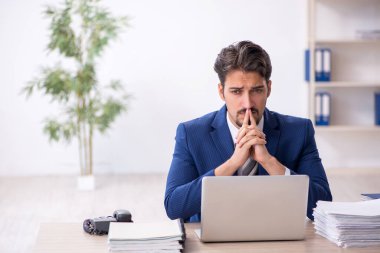 Ofiste çalışan genç bir erkek.