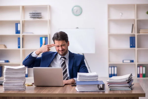 Jovem funcionário masculino infeliz com excesso de trabalho no escritório — Fotografia de Stock