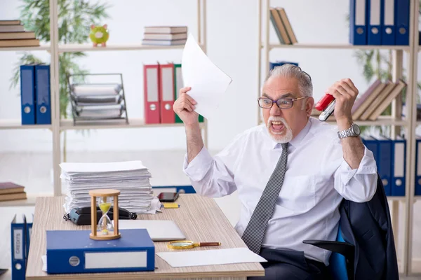 Old male employee in time management concept — Stock Photo, Image