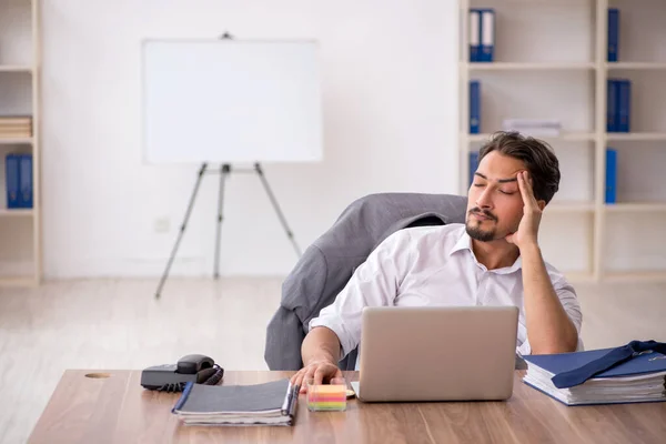 Jeune employé masculin assis dans le bureau — Photo