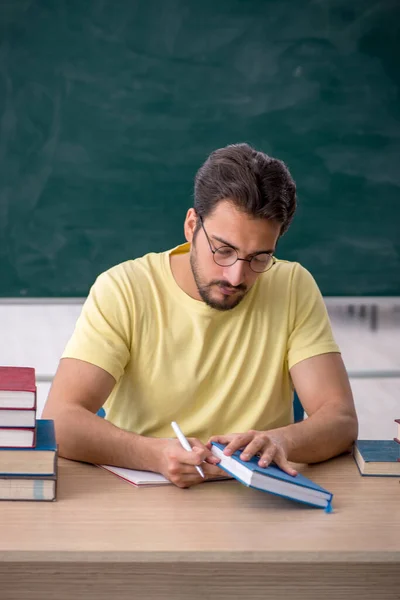 Joven estudiante masculino preparándose para los exámenes en el aula —  Fotos de Stock