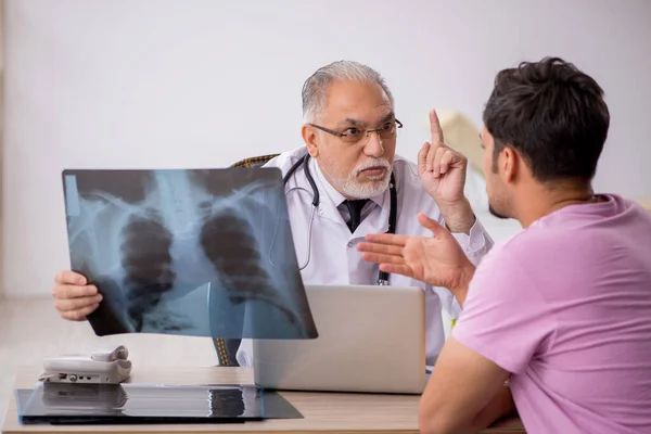 Jonge mannelijke patiënt op bezoek bij oude mannelijke arts radioloog — Stockfoto
