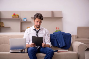 Genç erkek çalışan salgın sırasında evden çalışıyor.