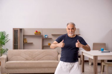 Yaşlı adam evde spor yapıyor.
