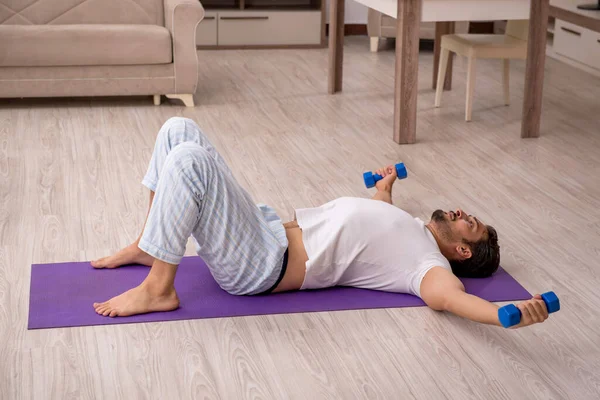 Genç adam evde spor yapıyor.