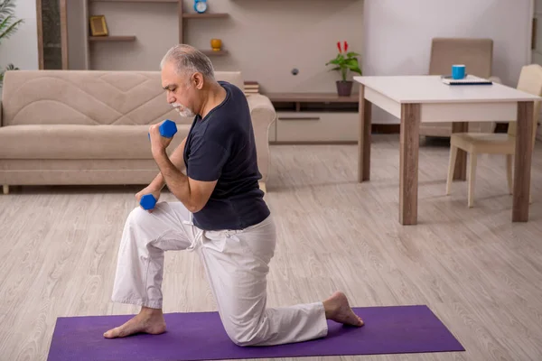 Velho fazendo exercícios esportivos em casa — Fotografia de Stock