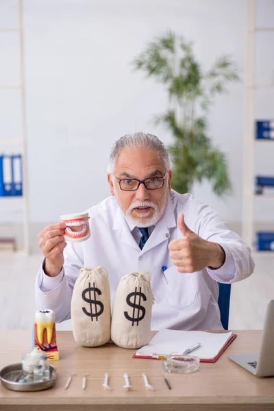 Velho médico dentista masculino em conceito de remuneração — Fotografia de Stock