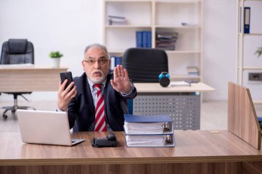 Ofiste çalışan yaşlı bir erkek.