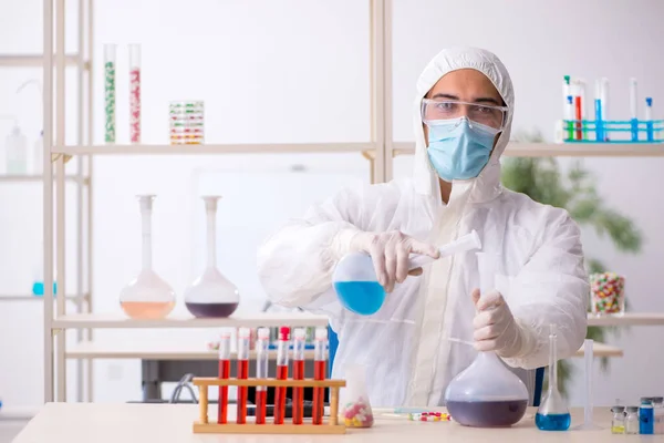 Giovane chimico maschile seduto in laboratorio durante la pandemia — Foto Stock