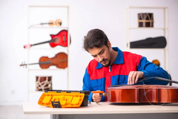 修理工作场所乐器的年轻男性修理工 — 图库照片