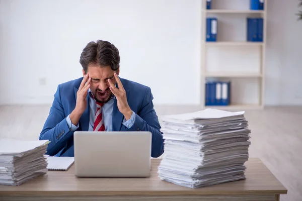 Junge männliche Mitarbeiter und zu viel Arbeit im Büro — Stockfoto