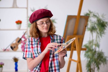 Genç kız evde resim yapmaktan hoşlanıyor.