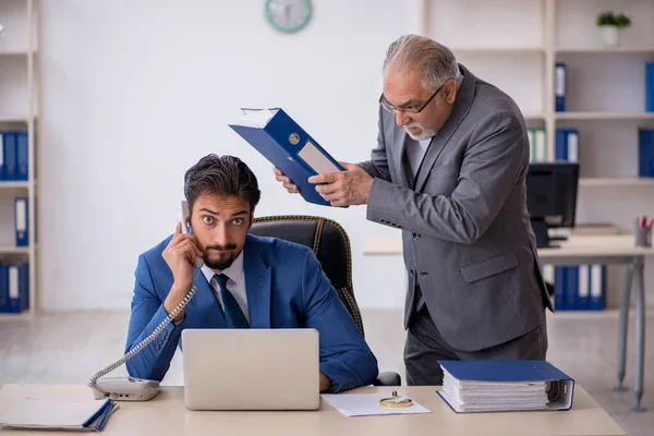 Old male boss and young male employee working in the office — Stock Photo, Image